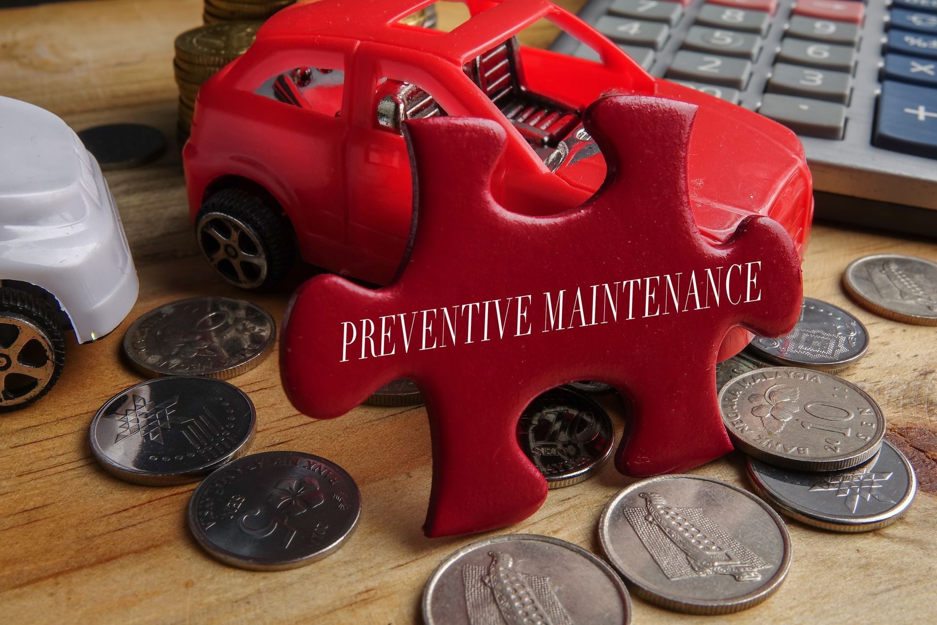 PREVENTIVE MAINTENANCE CONCEPT: Concept of repair, maintenance and servicing of machines. Model of red cabriolet with opened doors and hood and wrench on wooden surface